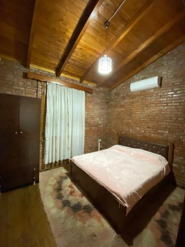 a bedroom with a bed and a brick wall at Vila Mario Berat in Berat