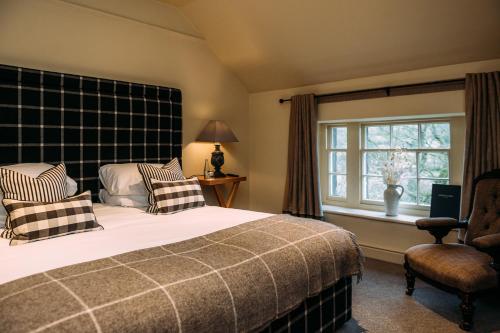a bedroom with a large bed and a window at The Assheton Arms in Clitheroe