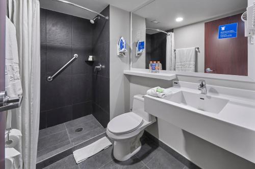 a bathroom with a toilet and a sink and a shower at City Express by Marriott Monterrey Aeropuerto in Monterrey