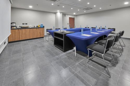 a conference room with a long blue table and chairs at City Express by Marriott Monterrey Aeropuerto in Monterrey