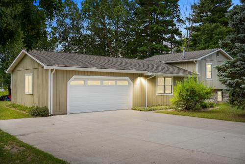 a house with a garage with a driveway at LAKEFRONT PARADISE 4 bedroom Home w direct lake access, Pets OK in Traverse City