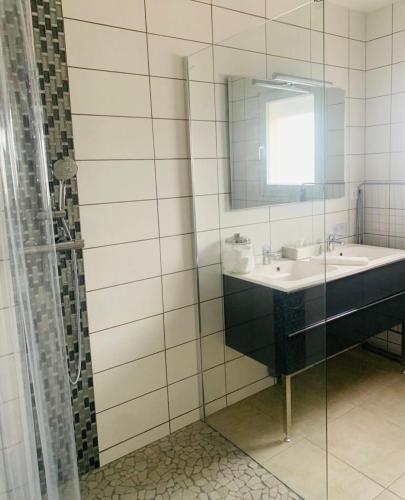 W łazience znajduje się umywalka i lustro. w obiekcie Maison plain-pied avec accès PMR w mieście Warcq