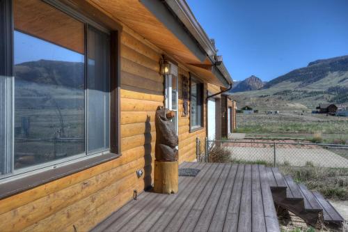 a wooden porch with a statue on the side of a building at Warrick Cabin in Creede