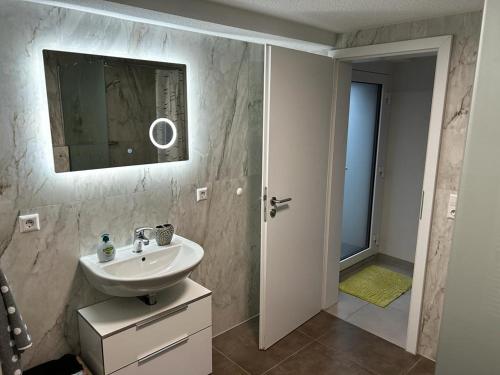 ein Bad mit einem Waschbecken und einem Spiegel in der Unterkunft Minalya Home in Laufenburg