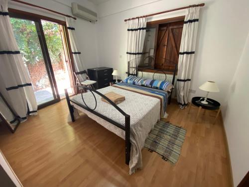 ein Schlafzimmer mit einem Bett und einem großen Fenster in der Unterkunft Gold Mountain House in Moutoullas