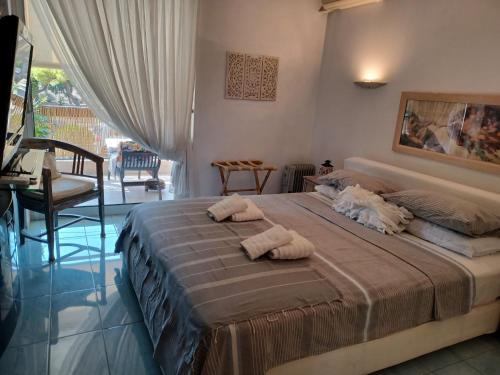 ein Schlafzimmer mit einem Bett mit zwei Handtüchern darauf in der Unterkunft South Coast Voula Beach Sea RIVIERA Suite in Athen