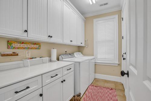 a kitchen with white cabinets and a washing machine at Marsh Madness 5 Bdrm Low Country Lifestyle in Pawleys Island