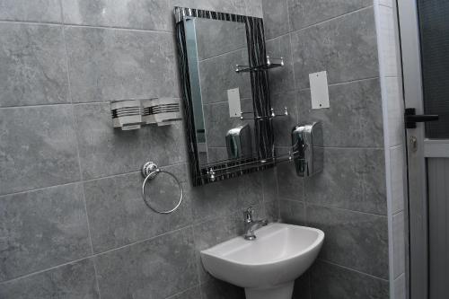 y baño con lavabo y espejo. en Cozy Apartment Entebbe en Wakiso