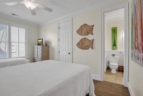 a white bedroom with a bed and a toilet at Marsh Madness 5 Bdrm Low Country Lifestyle in Pawleys Island