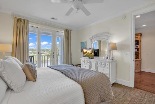 a bedroom with a bed and a balcony with a television at Marsh Madness 5 Bdrm Low Country Lifestyle in Pawleys Island