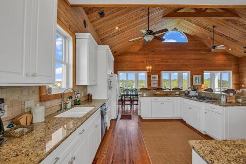 a kitchen with white cabinets and a ceiling fan at Marsh Madness 5 Bdrm Low Country Lifestyle in Pawleys Island