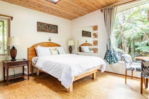a bedroom with a large bed and a window at Pahoehoe- Hale Kumu La'au at Volcano in Volcano