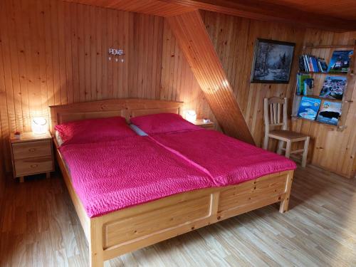 a bedroom with a wooden bed with a purple comforter at Počitniška hiška Kašta in Luče