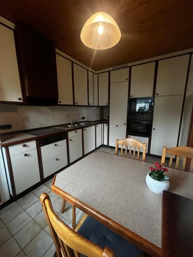 a kitchen with a table and chairs and a kitchen with white cabinets at Nord Haus in Kiel
