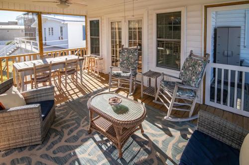 a porch with wicker chairs and a table on a porch at 5BR Scenic View 3 Minutes to the Beach in Pawleys Island