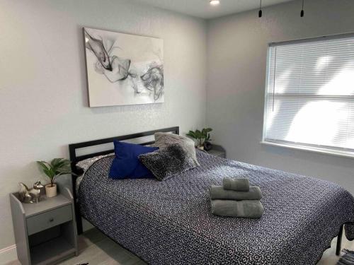 a bedroom with a bed with blue pillows and a window at Charming 2-Bedrooms Central Clearwater Apartment With Private Backyard in Clearwater