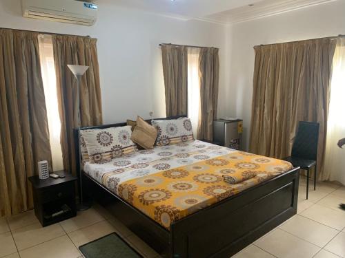a bedroom with a bed with a yellow comforter at Sandpark Place, West Hills in Accra