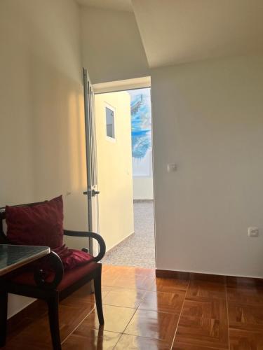 ein Wohnzimmer mit einem Stuhl und einer Tür in der Unterkunft Casa BB&Djassi in Ponta do Sol