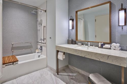a bathroom with a tub and a sink and a mirror at Walt Disney World Swan Reserve in Orlando
