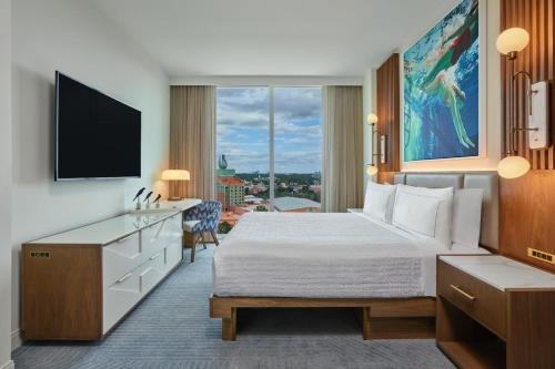 a hotel room with a bed and a flat screen tv at Walt Disney World Swan Reserve in Orlando