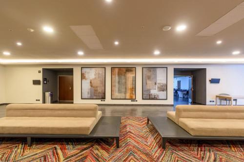 a living room with two couches and a rug at City Express Plus by Marriott Bogota Aeropuerto in Bogotá