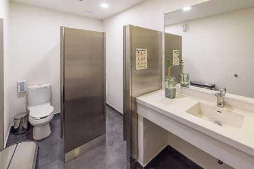 a bathroom with a toilet and a sink at City Express Plus by Marriott Bogota Aeropuerto in Bogotá