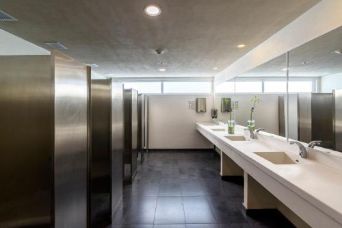 a bathroom with three sinks and a row of mirrors at City Express Plus by Marriott Bogota Aeropuerto in Bogotá