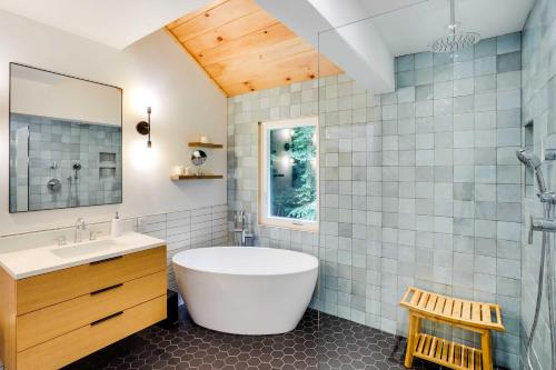 a bathroom with a tub and a sink at Fully Remodeled Saugerties Retreat on 7 Acres! in Saugerties