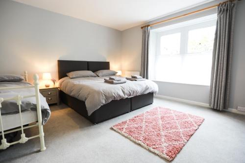 a bedroom with a bed and a large window at Woodside Oak hot tub & pool sleeps 4-6 in Bideford