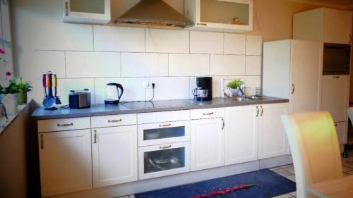 a kitchen with white cabinets and a counter top at Monteurwohnung in Emsbüren