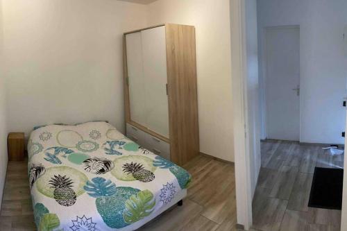 a small bedroom with a bed and a mirror at Logement 3 personnes. in Vitry-le-François