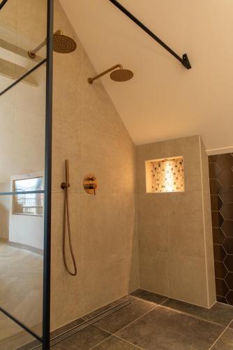 a shower with a glass door in a bathroom at Bed & Breakfast Bellesza in Oldeberkoop