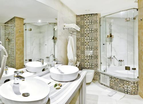a bathroom with two sinks and a shower and a tub at Fes Heritage Boutique luxury Hotel in Fès