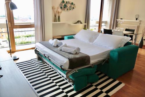 a bed in a living room with a green couch at - ARENA - Panoramic VIEW - Central Apartment in Verona