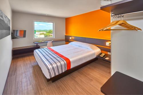 a bedroom with a bed and a window at City Express Junior by Marriott Tuxtepec in San Juan Bautista Tuxtepec