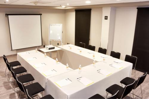 a meeting room with a large white table and chairs at City Express by Marriott Leon in León