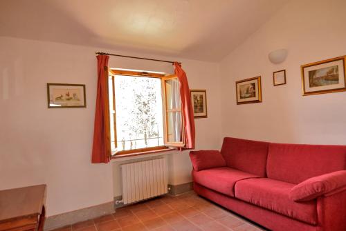 a living room with a red couch and a window at I Casali Della Ghisleria in Ospedalicchio