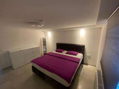 a bedroom with a bed with purple sheets and purple pillows at Minalya Home in Laufenburg
