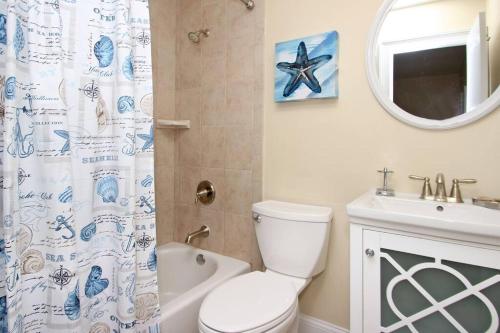 ein Badezimmer mit einem WC, einem Waschbecken und einem Spiegel in der Unterkunft Cute 2 bedroom, 2 bath Condo at Folly Field Beach in Hilton Head Island