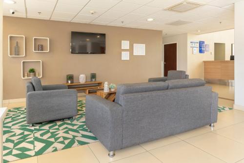 a waiting room with two chairs and a flat screen tv at City Express by Marriott San José Costa Rica in San José