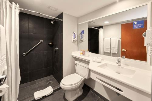 y baño con aseo, lavabo y ducha. en City Express by Marriott Tampico, en Tampico