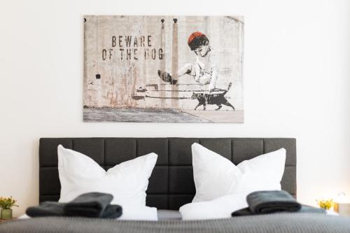 a room with a bed with white pillows and a painting on the wall at Apartments an der Oper - Innenstadt - Zentral - Küche - Wifi - Powered by Ko-Living in Halle an der Saale