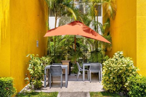 a table and chairs with an orange umbrella at City Express by Marriott San José Costa Rica in San José