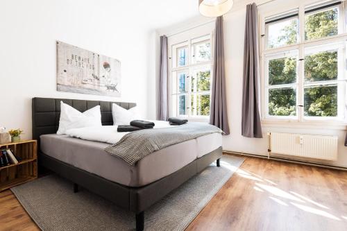 a bedroom with a large bed and two windows at Apartments an der Oper - Innenstadt - Zentral - Küche - Wifi - Powered by Ko-Living in Halle an der Saale