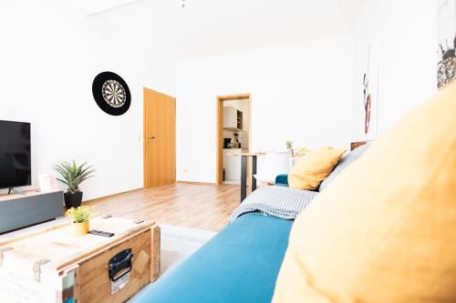 a living room with a blue couch and a tv at Apartments an der Oper - Innenstadt - Zentral - Küche - Wifi - Powered by Ko-Living in Halle an der Saale
