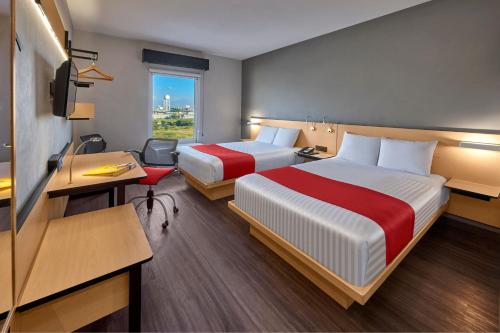 a hotel room with two beds and a desk at City Express by Marriott San Luis Potosi Zona Universitaria in San Luis Potosí