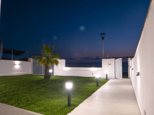 a pathway leading to a house at night with lights at Villa Marisa - Villa di Lusso Fronte Spiaggia in Cittadella del Capo