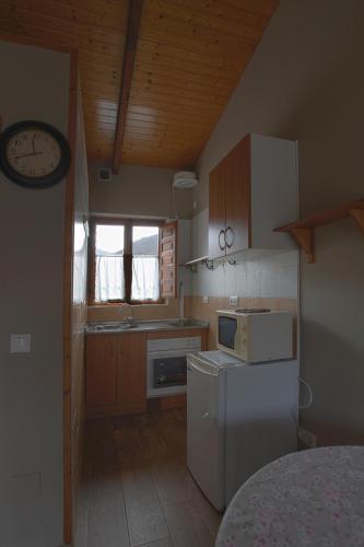 a kitchen with a refrigerator and a clock on the wall at Apartamentos El Campal in Felechosa