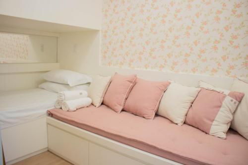a pink and white couch with pink and white pillows at Flat 333 - Luxo e Vista da Pedra Azul in Pedra Azul