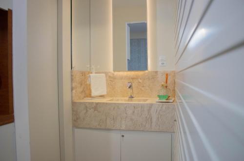 a bathroom with a sink and a mirror at Flat 333 - Luxo e Vista da Pedra Azul in Pedra Azul